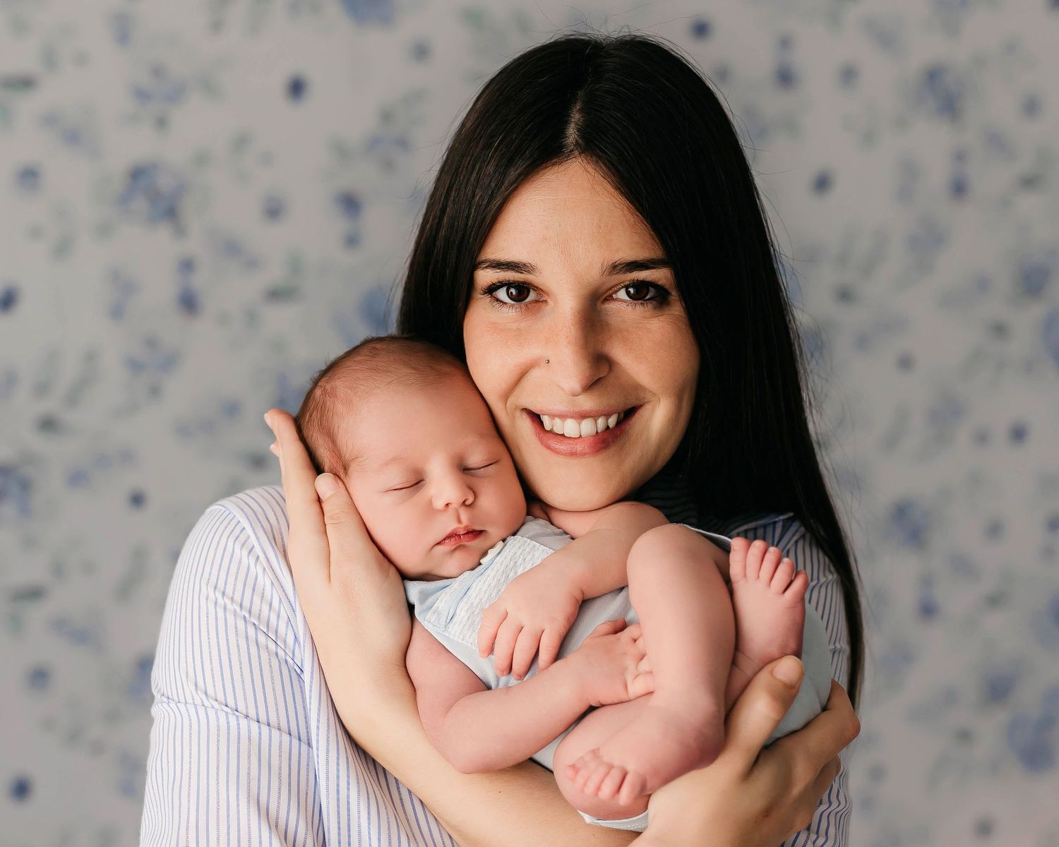 Retrato de un recién nacido en los brazos de su madre durante una sesión de fotos.