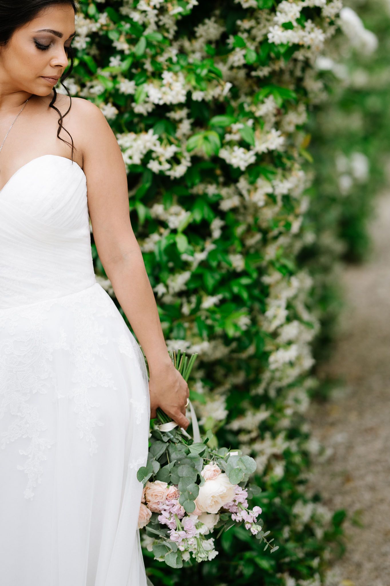 An elegant white wedding dress shown against a backdrop of flowering spring branches.