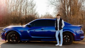 A bright blue sports car parked outdoors during golden hour.
