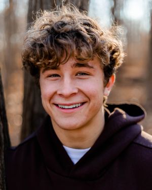 Close-up outdoor portrait with natural forest bokeh background.