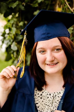 Close-up graduation photos showing navy cap with gold tassel against green foliage.