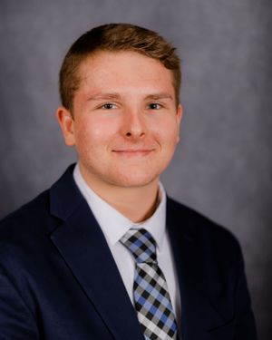 Formal headshot wearing dark suit and patterned tie.