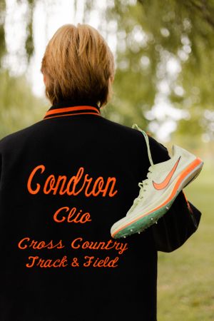 Back view of varsity jacket showing orange text and athletic team branding.