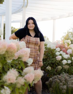 Outdoor portraits near blooming white and pink flowers with a gazebo backdrop.