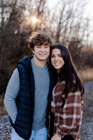Couple in casual winter clothing posing together outdoors.