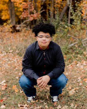 Casual outdoor photoshoot on fallen autumn leaves with black jacket and jeans.