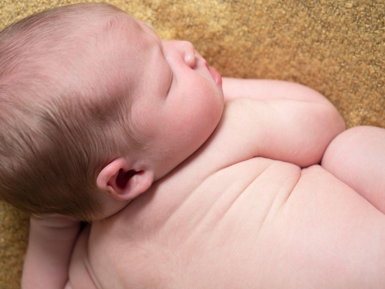 portrait of a newborn baby boy laying on a yellow blanket