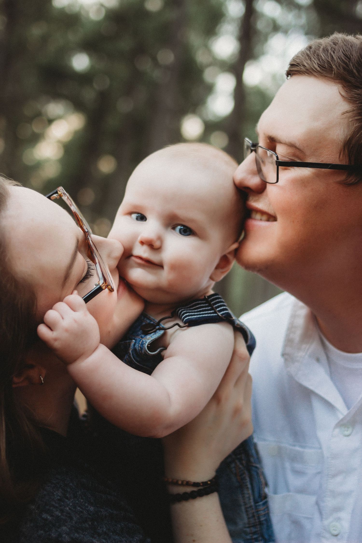 parents kissing baby