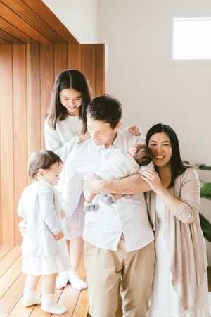 Family sharing joyful moments together in a bright room with wooden wall panels.