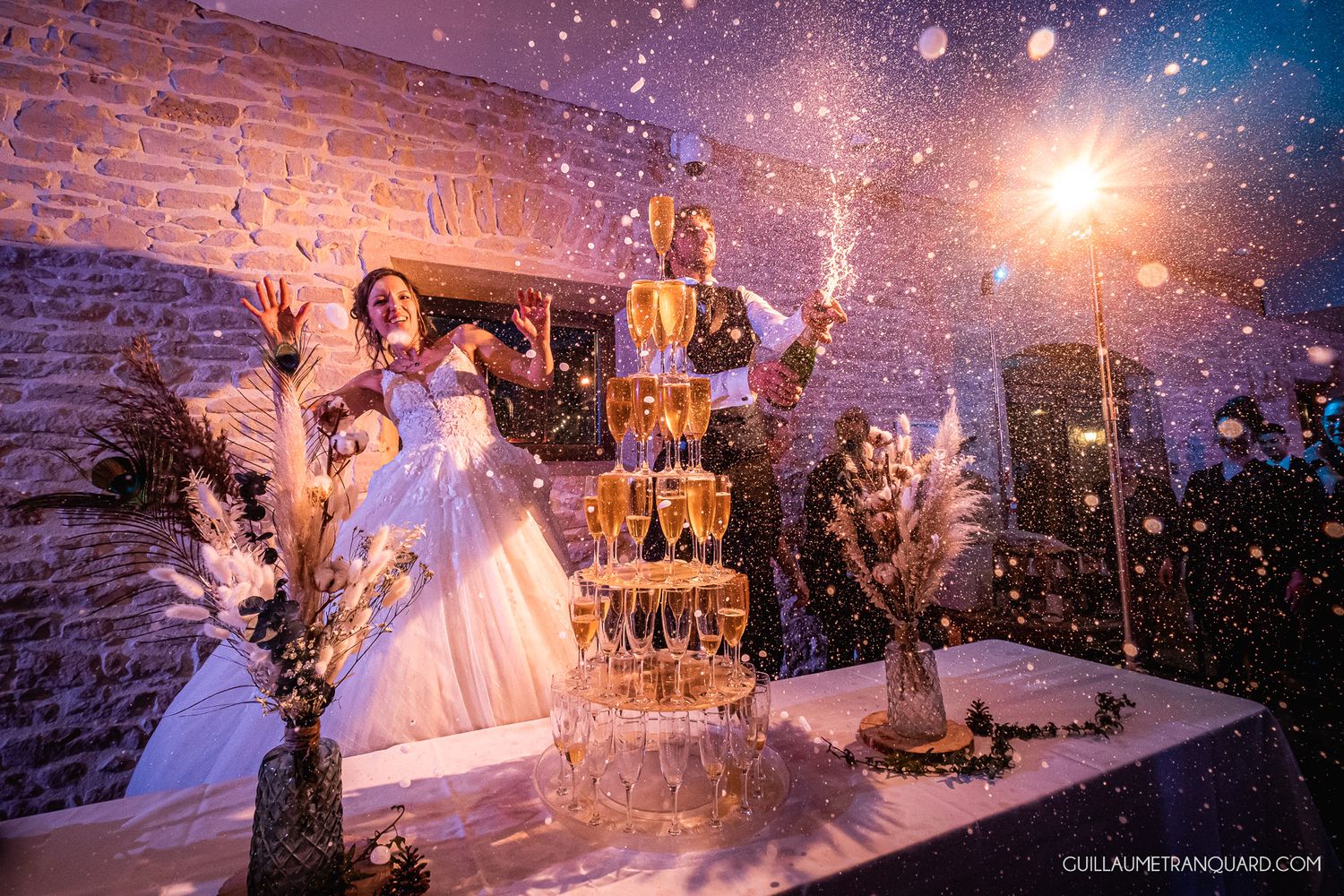Wedding reception table under twinkling lights with sparklers creating magical nighttime ambiance.