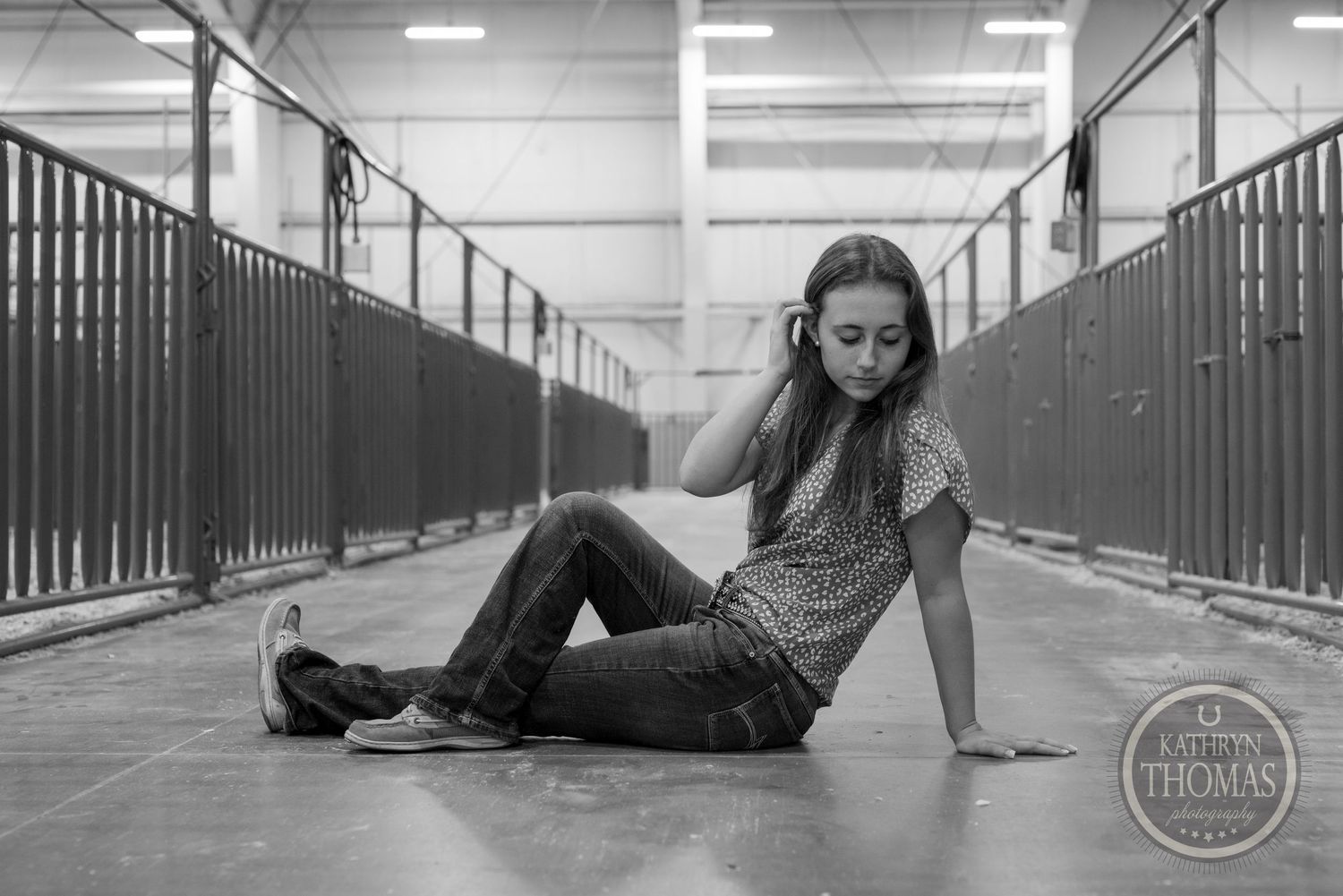 Black and white photo in a corridor with metal stalls and fluorescent lighting.