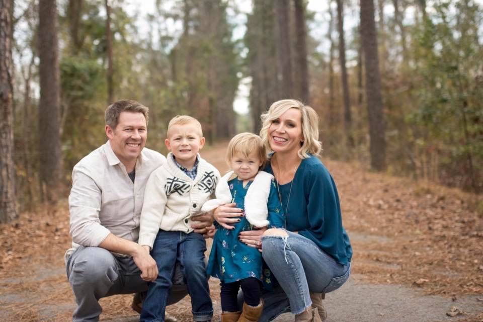 Family portrait session in a wooded forest setting during autumn.