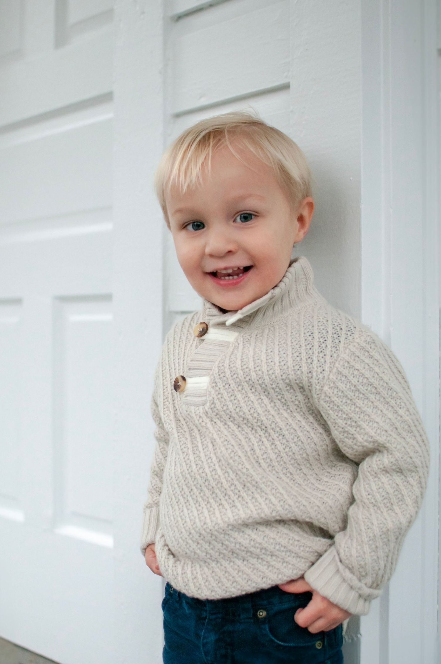Toddler standing by white house door in Sterling, VA
