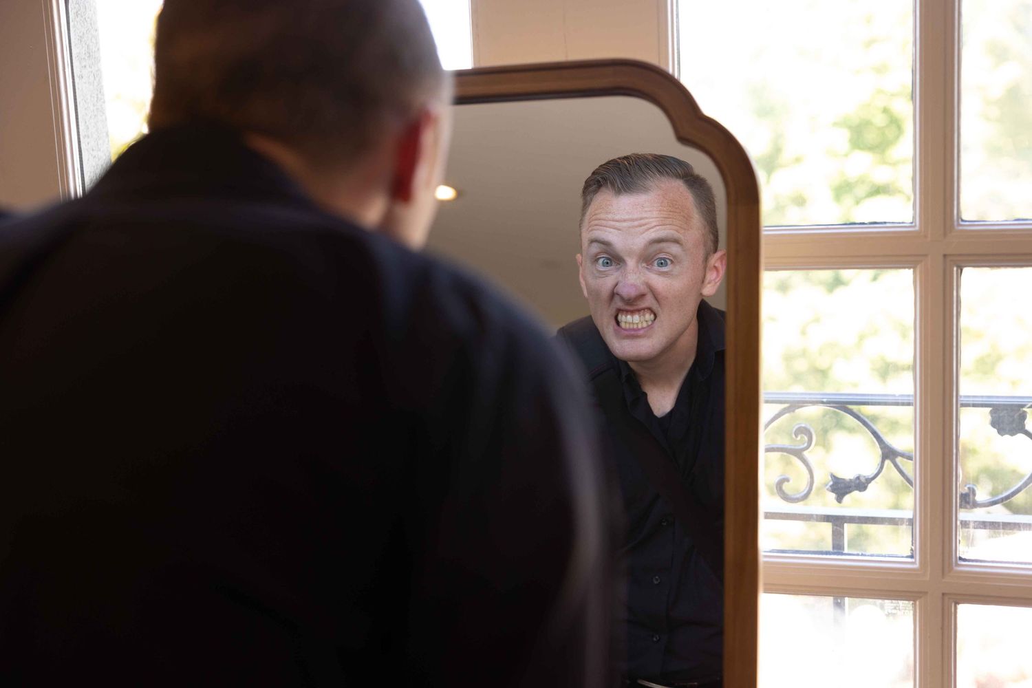 Reflection of person making funny face in mirror.