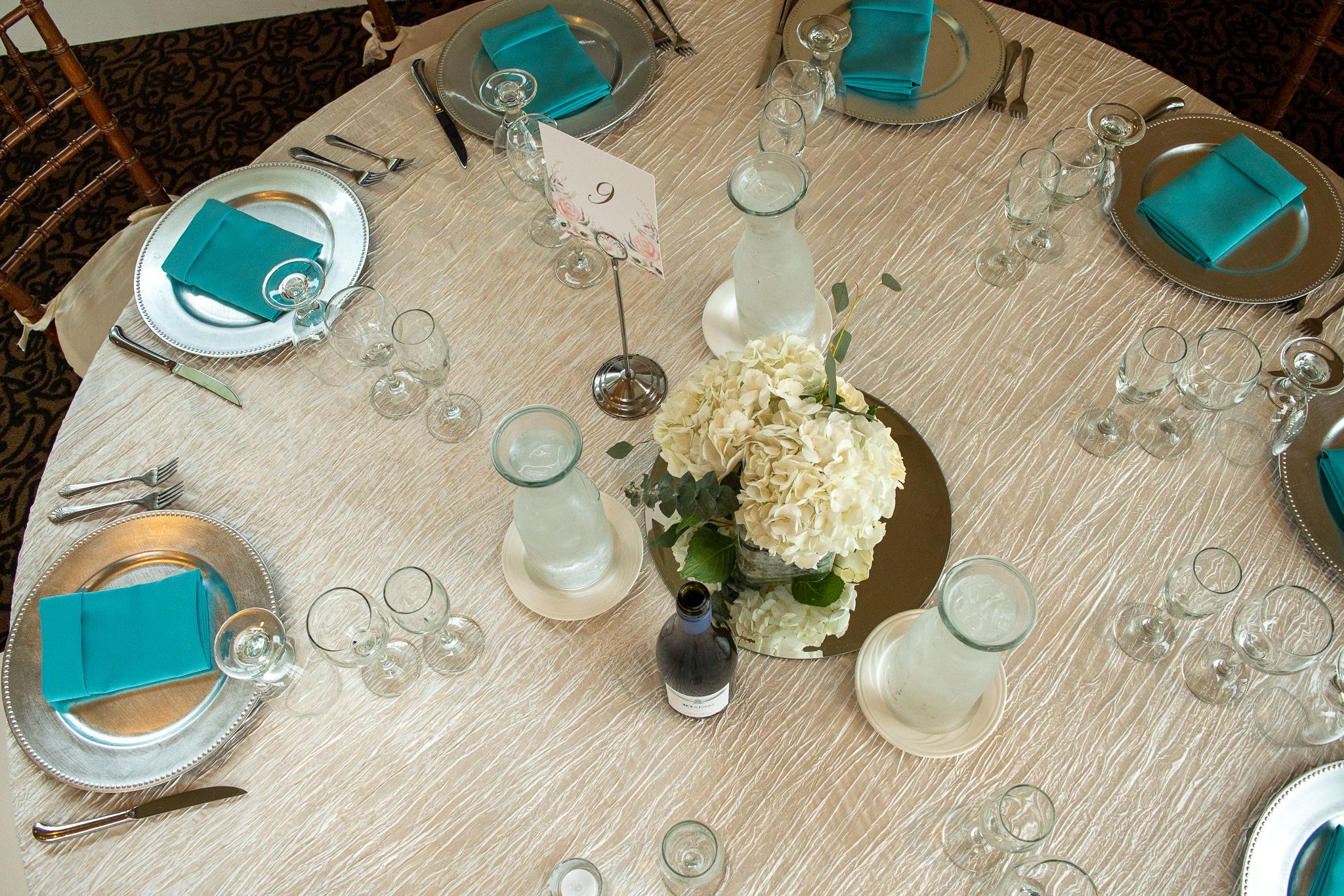 Flat Lay of formal table setting blues whites, golds glass champagne round circular