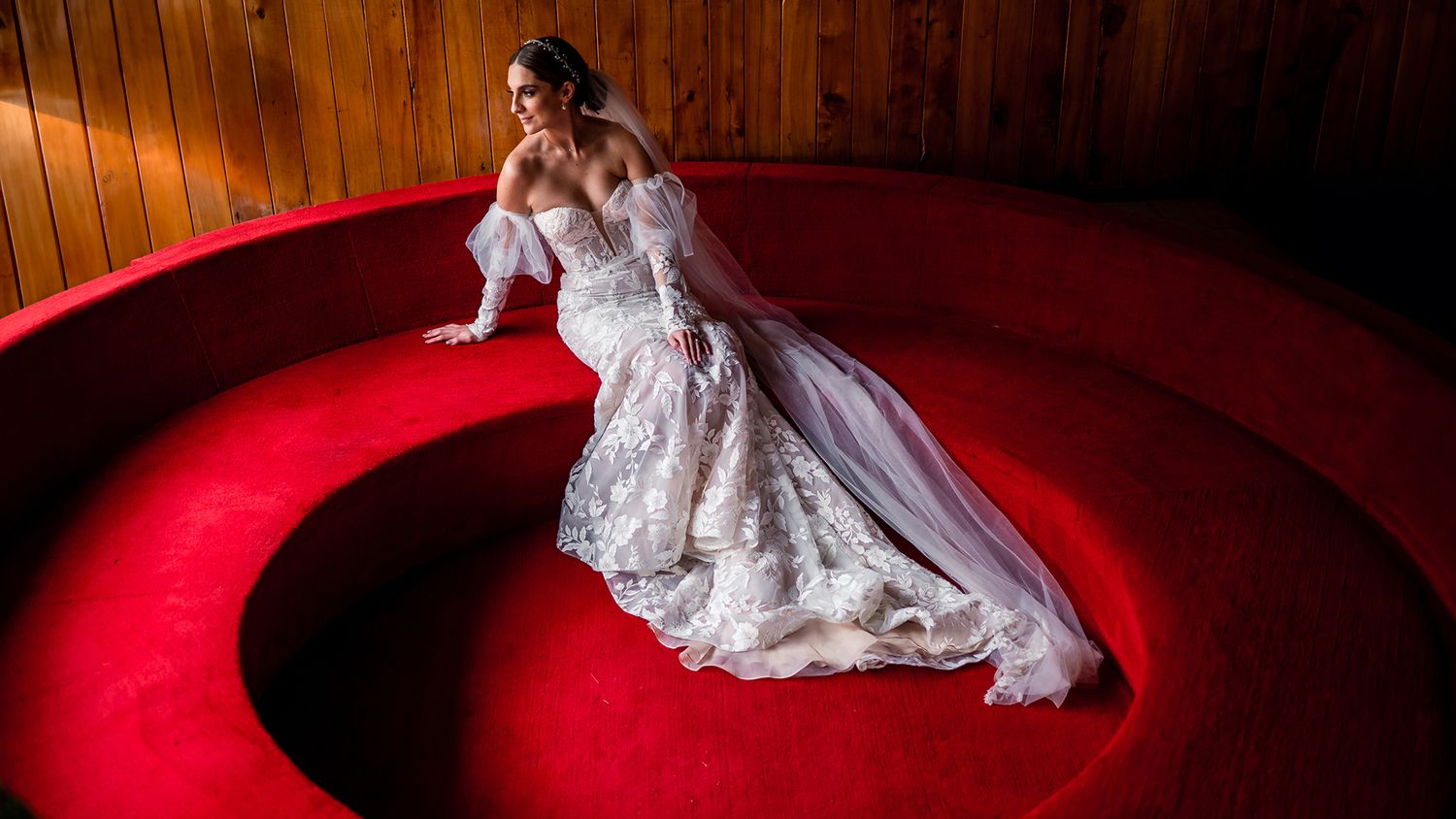 A dramatic scene with white fabric against a deep red background creates an artistic composition.