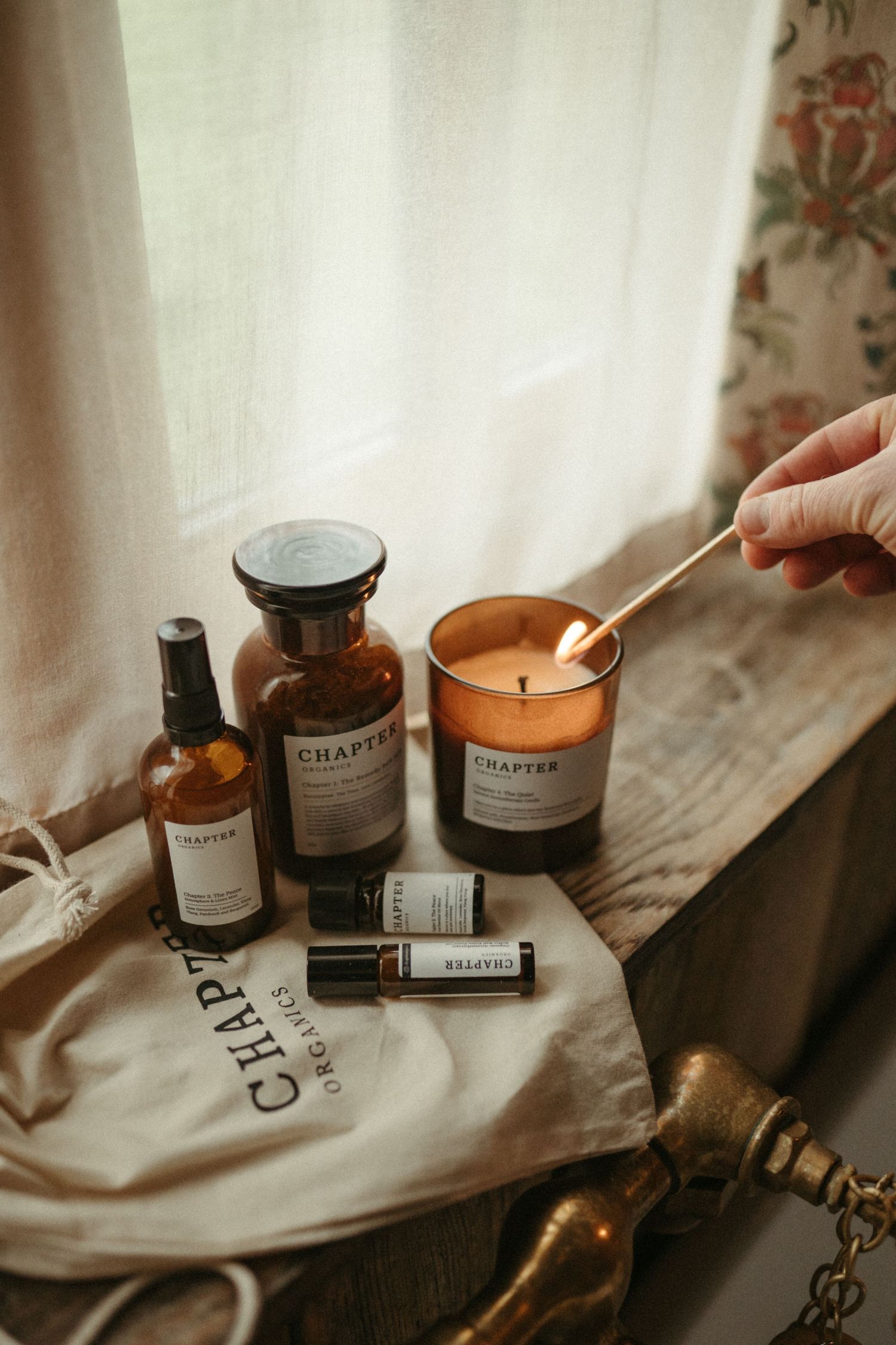 A collection of wellness products including candles and essential oils arranged on a wooden surface.