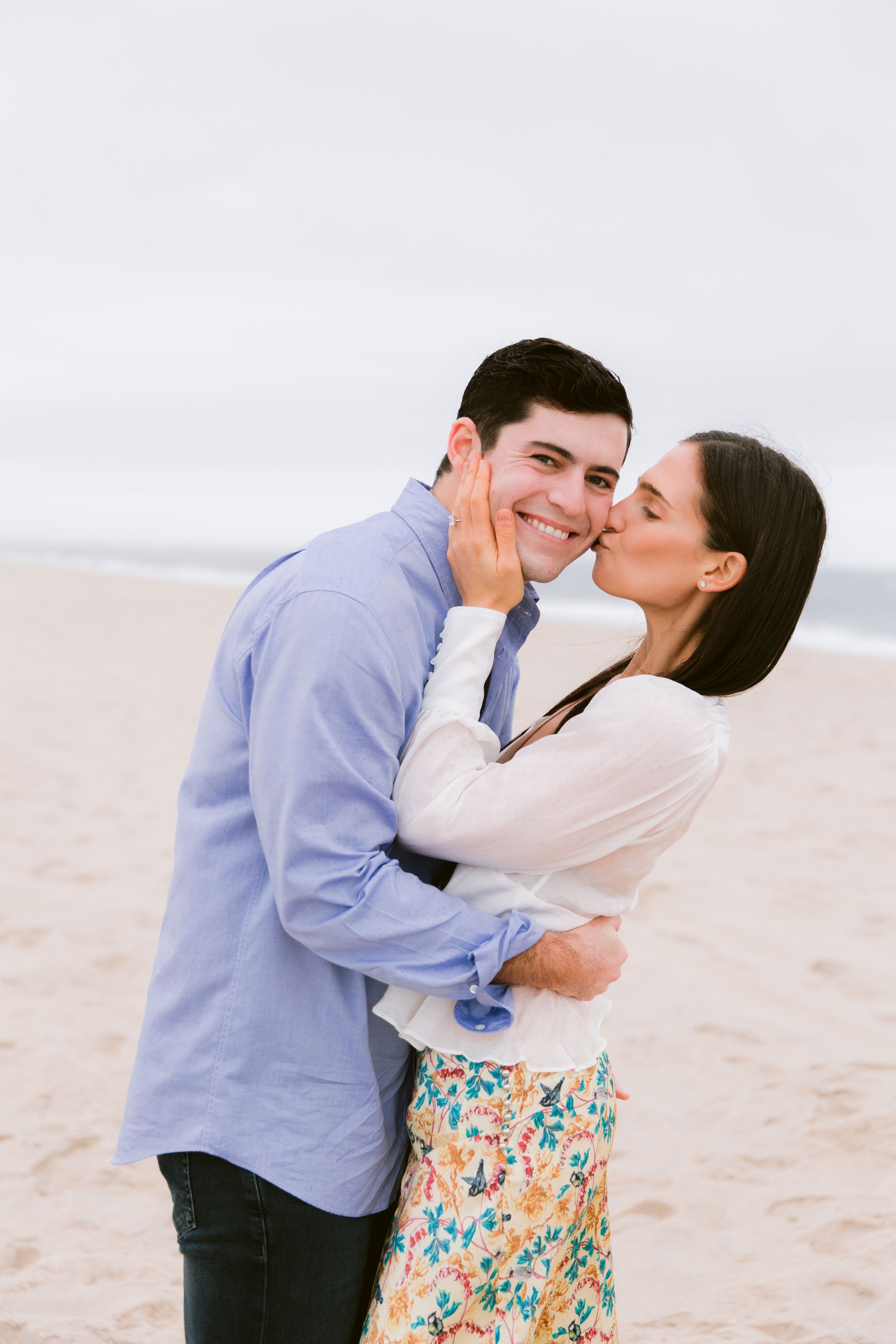 Romantic couple sharing tender moments on sandy beach.