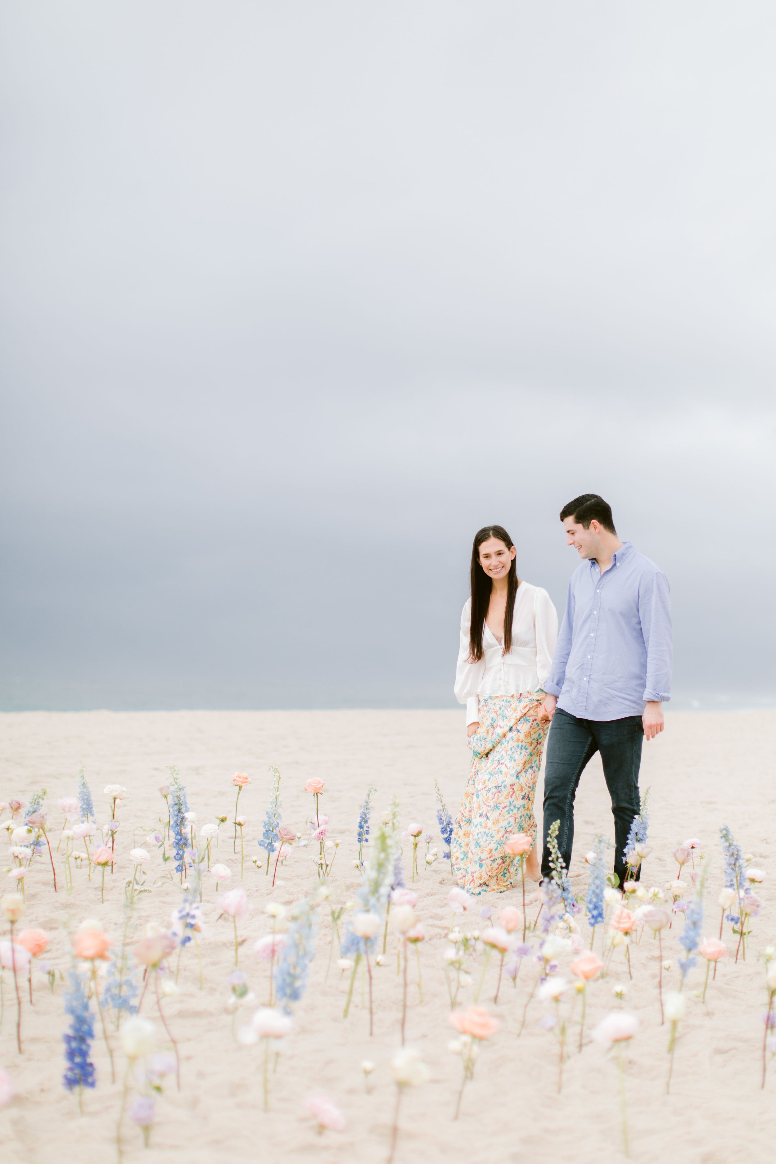 A romantic walk through a field of colorful flowers planted in sand.