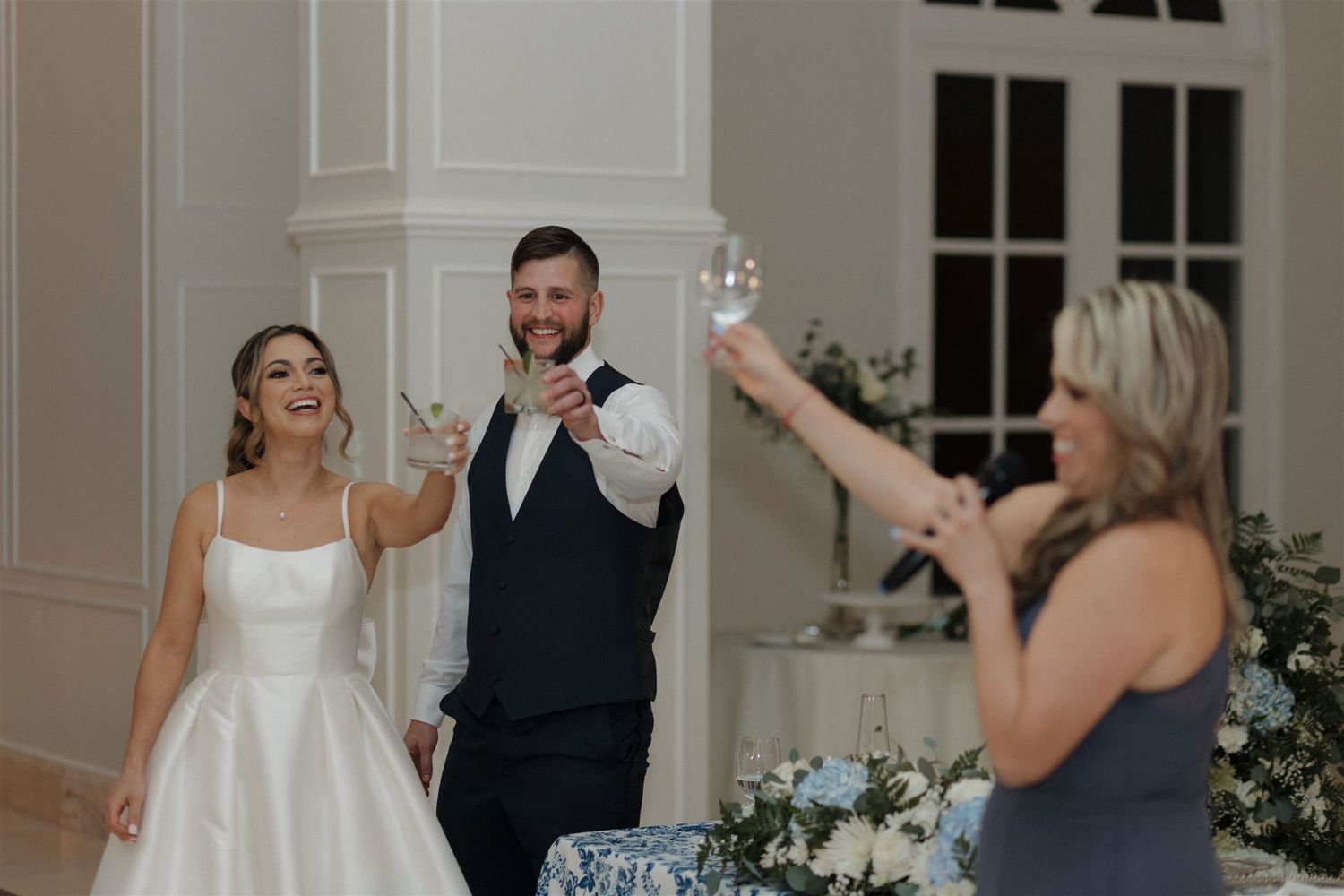 Wedding party raises champagne glasses in celebration toast.