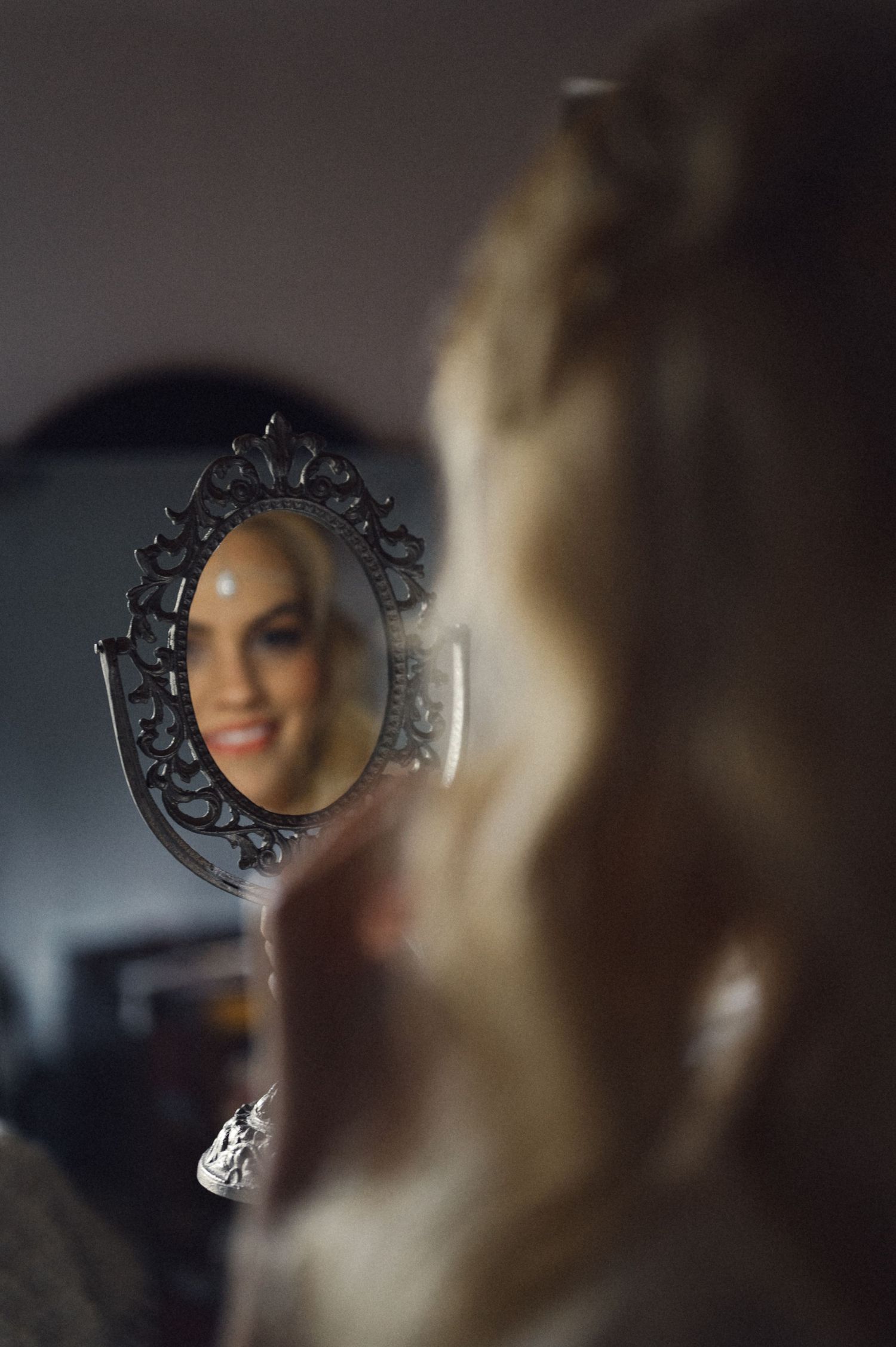Soft focus mirror reflection capturing a candid pre-wedding moment.