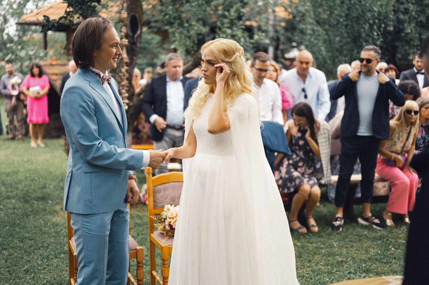A couple exchanges vows during an outdoor garden wedding ceremony.