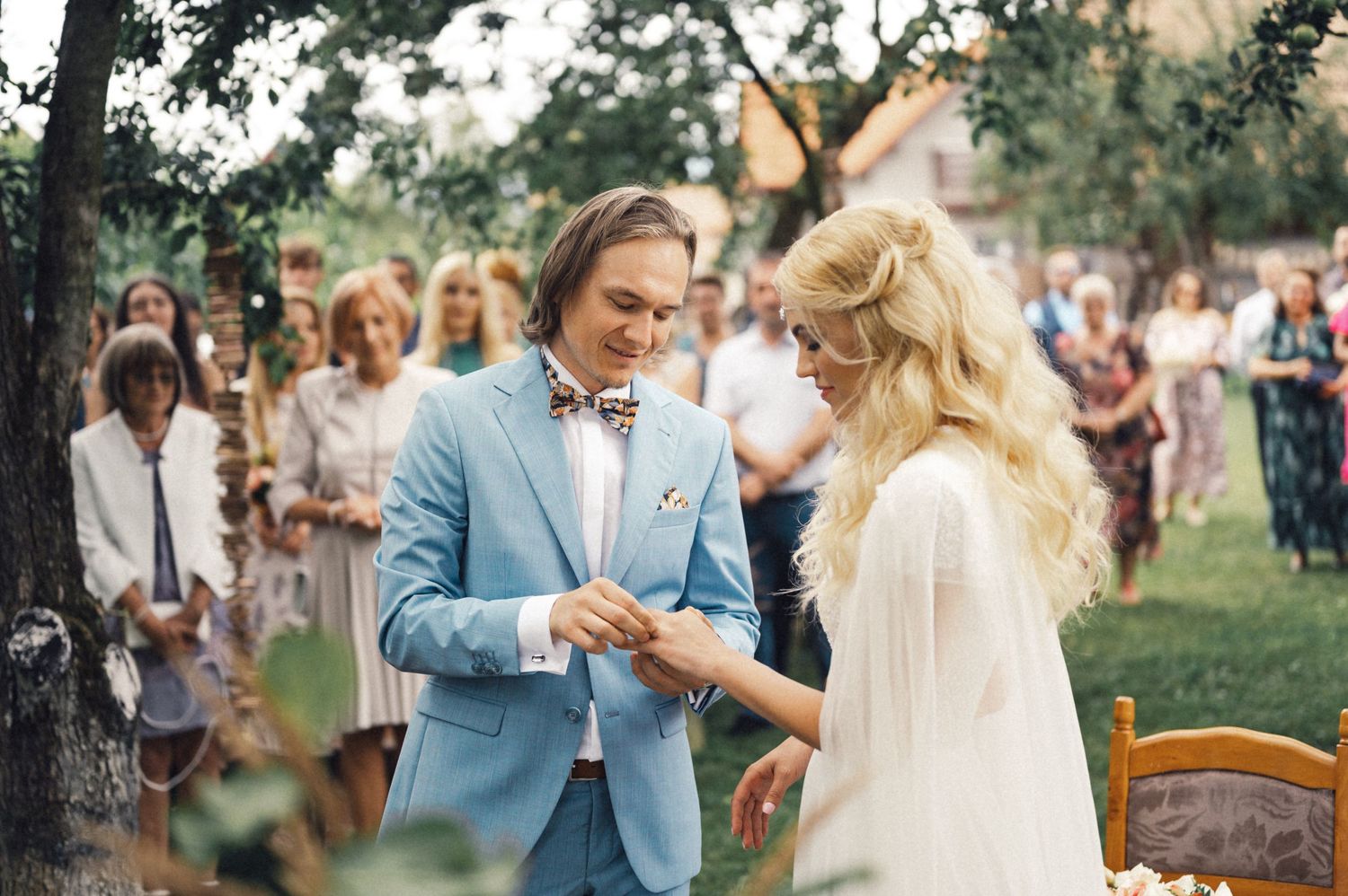 A couple exchanges rings during their garden wedding ceremony.