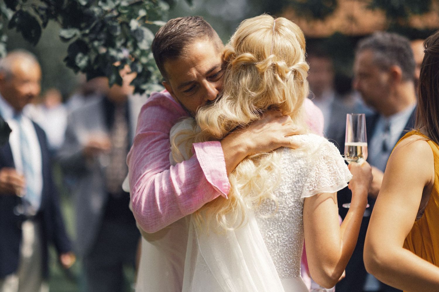 A warm embrace shared during an outdoor garden wedding celebration.