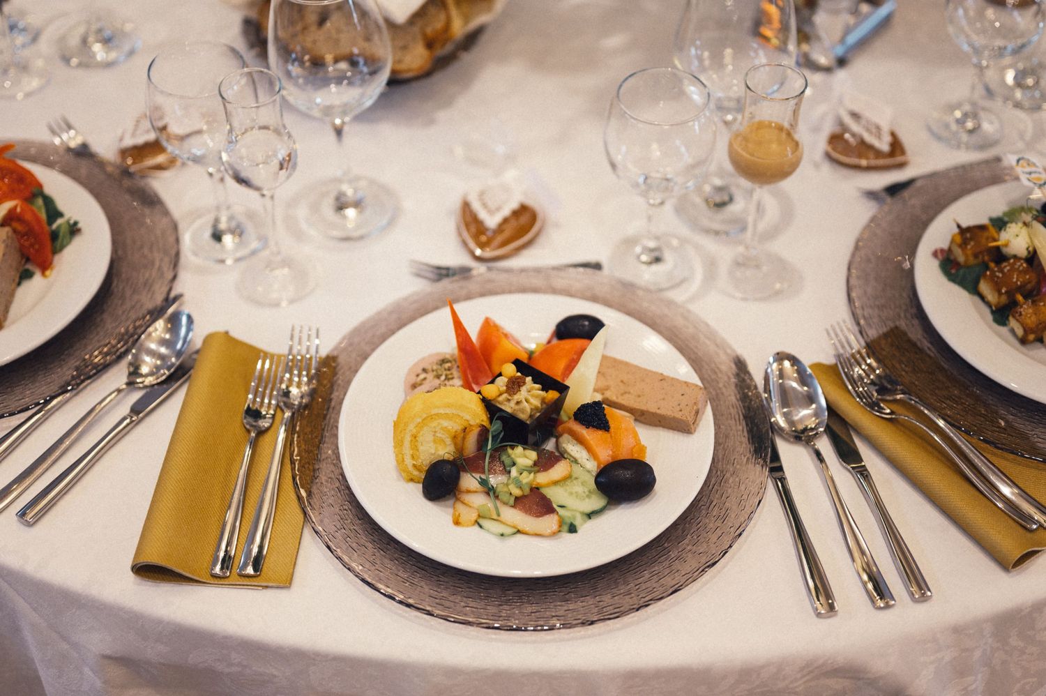 Plated dinner at wedding reception featuring seafood and vegetables with formal place settings.