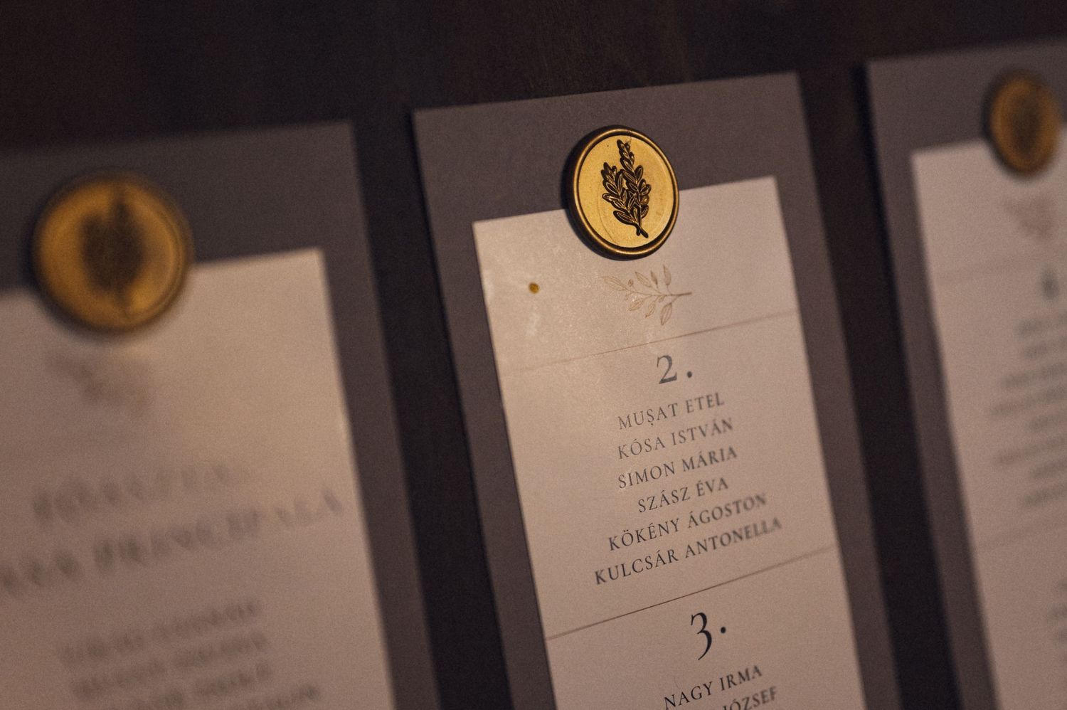 Wedding menu cards with elegant gold emblems displayed in a row.