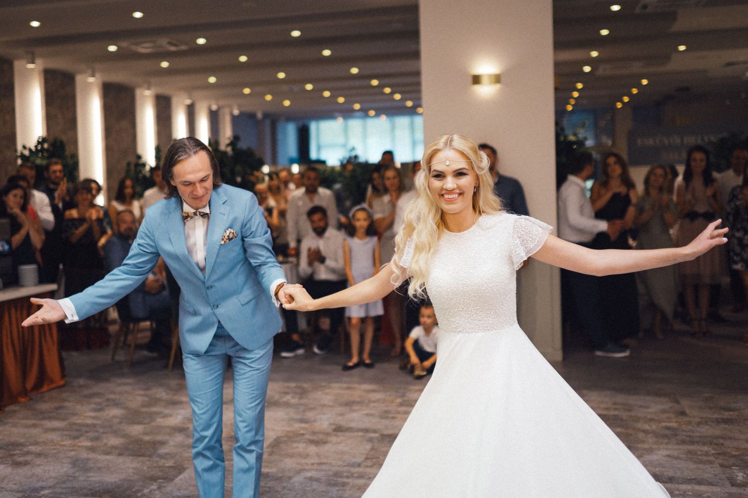 Bride and groom performing synchronized dance moves during their wedding reception.