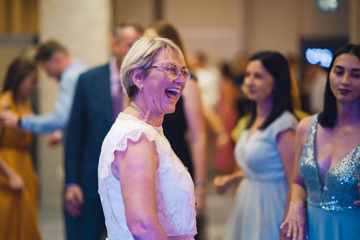 Guests laughing and enjoying themselves during a lively wedding reception.