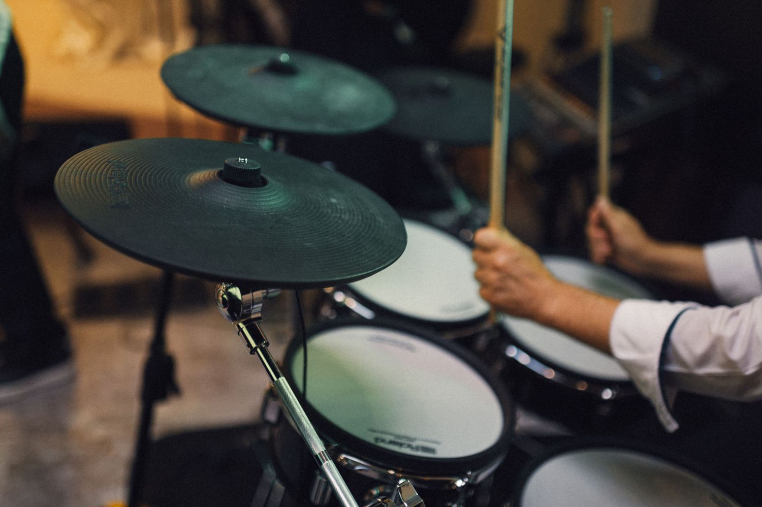 Close-up of electronic drum cymbals with drummer's hands in motion during performance.