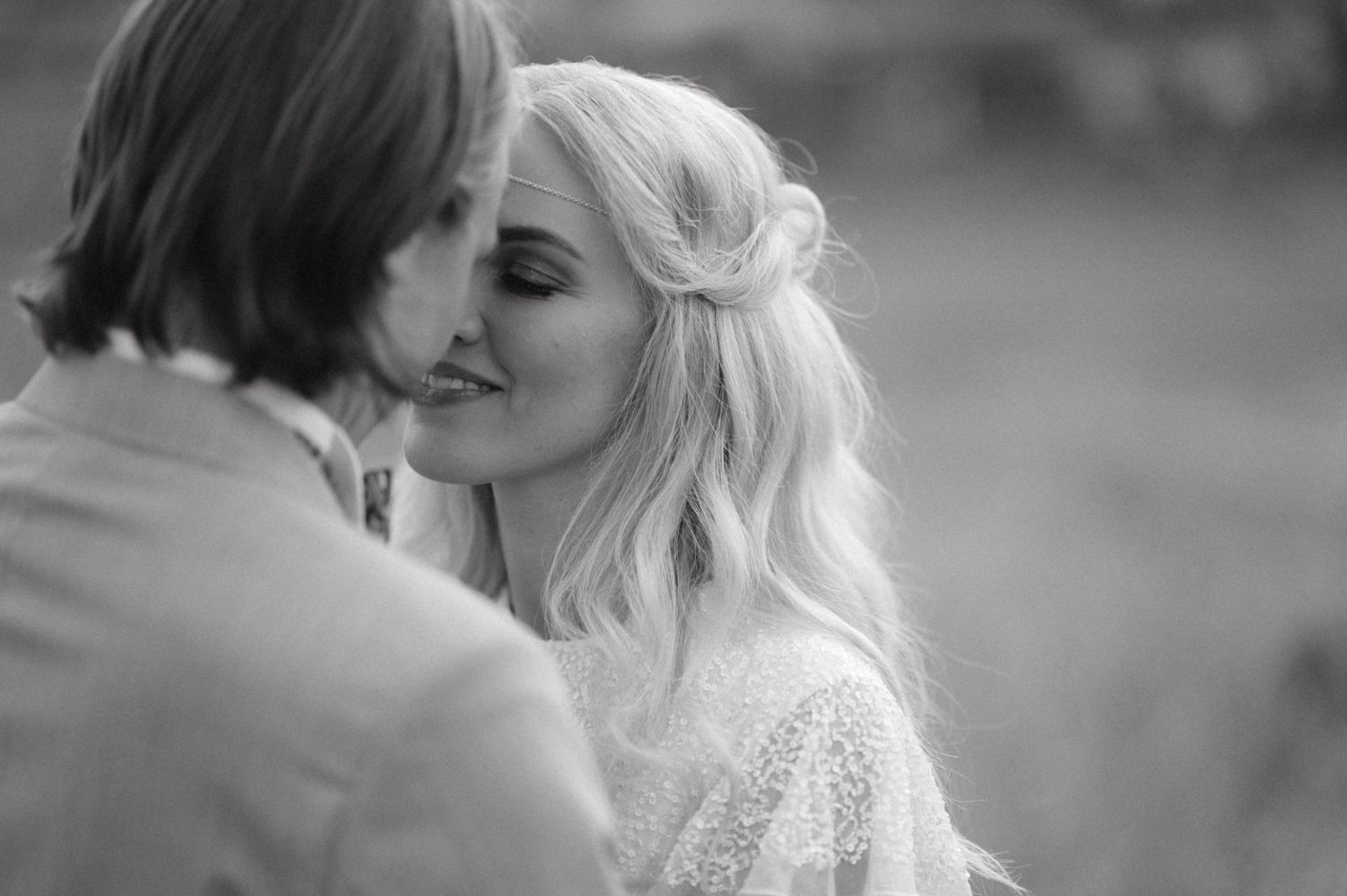 An intimate black and white portrait captures a tender moment between a couple.