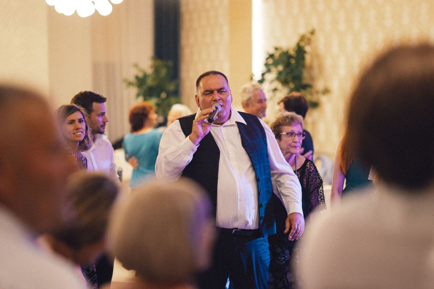 Guest singing into a microphone during a wedding reception performance.