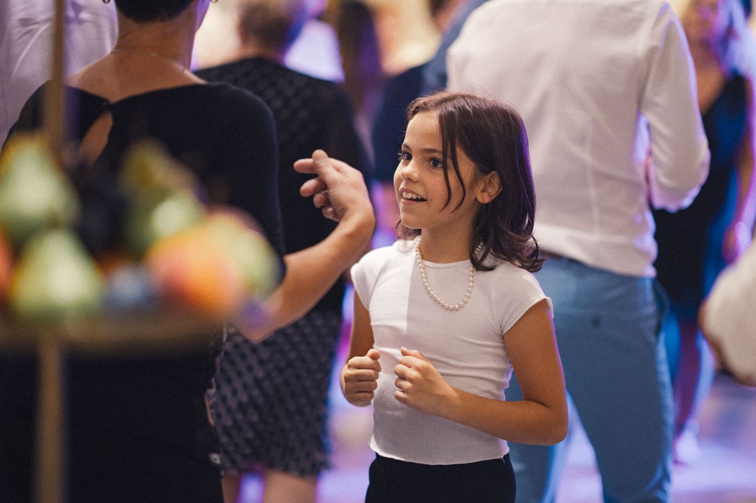 Young girl dancing and enjoying herself at an indoor celebration.