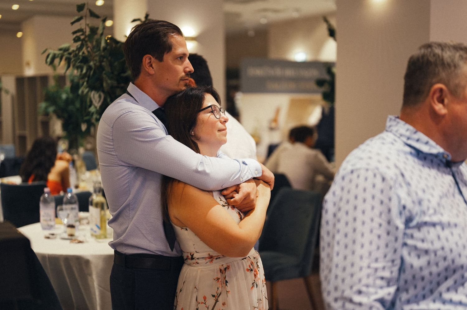 Romantic slow dance between couples at an elegant indoor wedding reception.