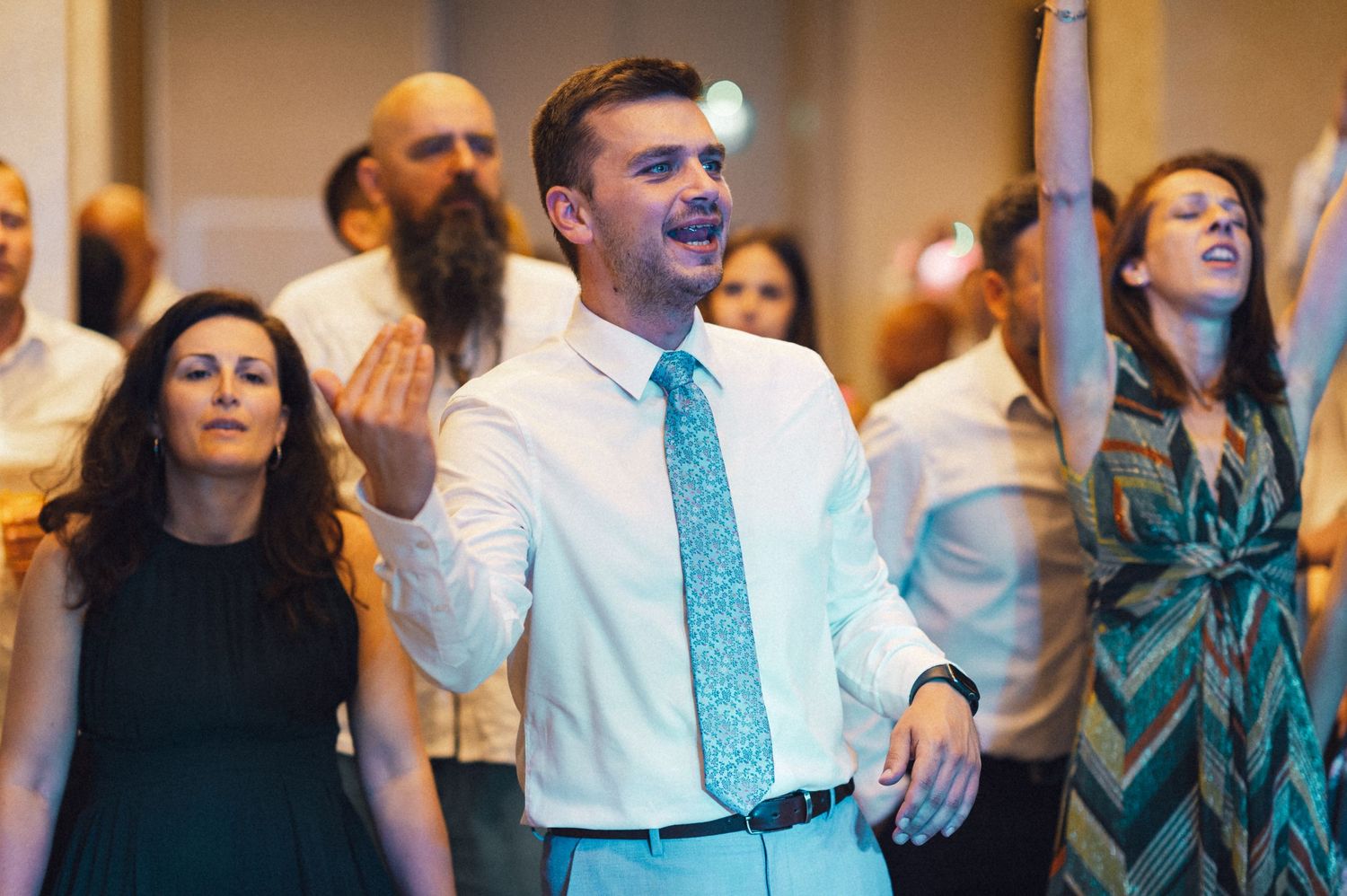 Wedding guests dancing enthusiastically during a reception celebration.
