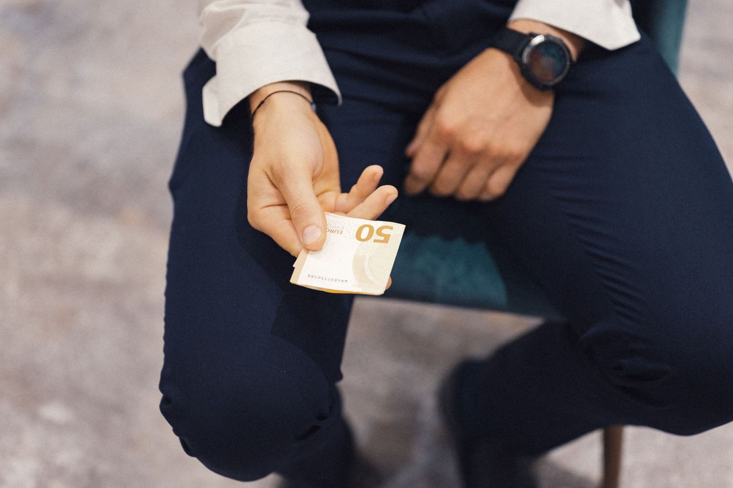 Close-up shot of someone in formal attire holding money.