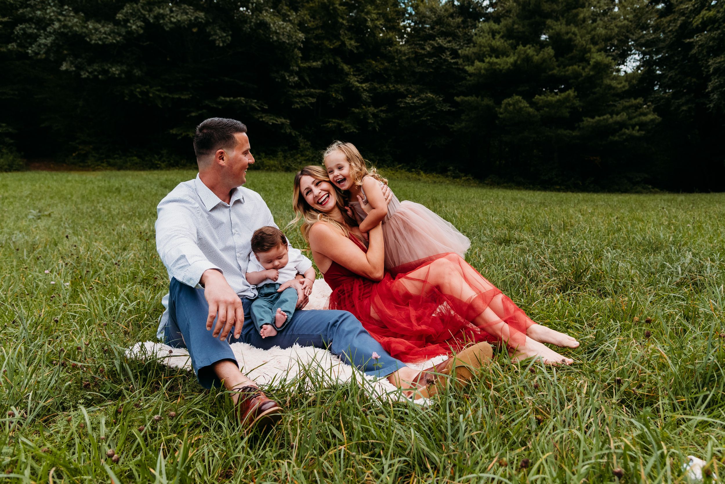 Family enjoying a sunny picnic together on grassy field.