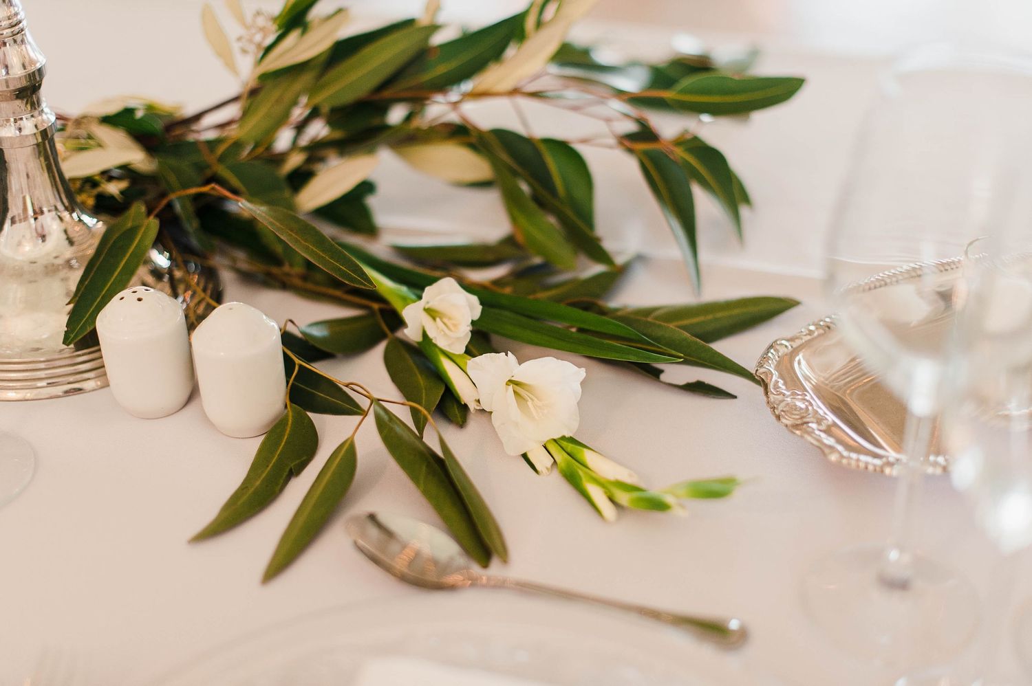 eucalyptus leaves and white Lilly's draped in table
