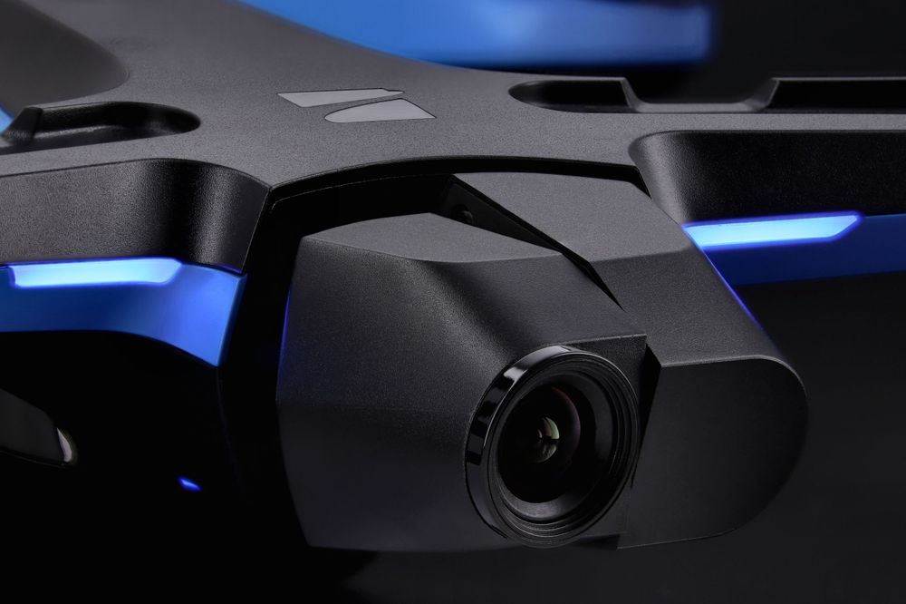 A closeup photo of the gimbal of a Skydio 2+ drone that is shot on a dark background with low-key lighting.