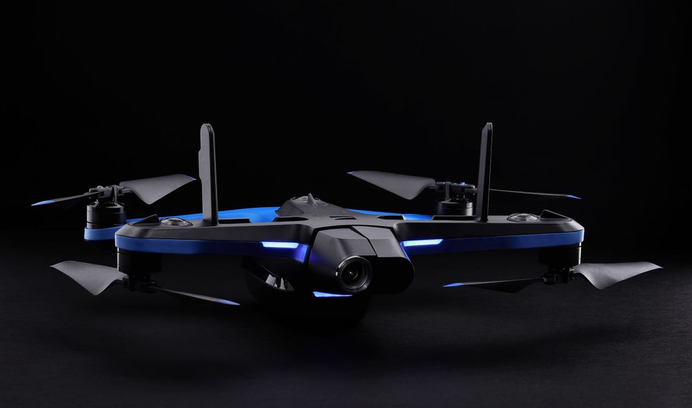 A Skydio 2+ drone photographed from a low angle with low-key lighting against a dark background.