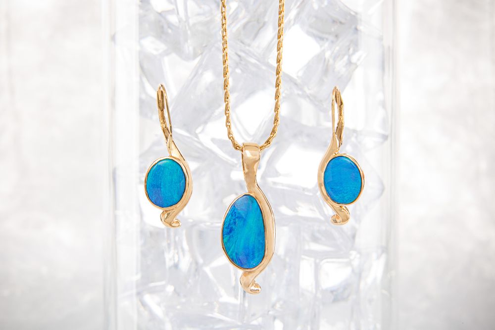 A custom made necklace and earring set made of 18K yellow gold and turquoise gemstone.