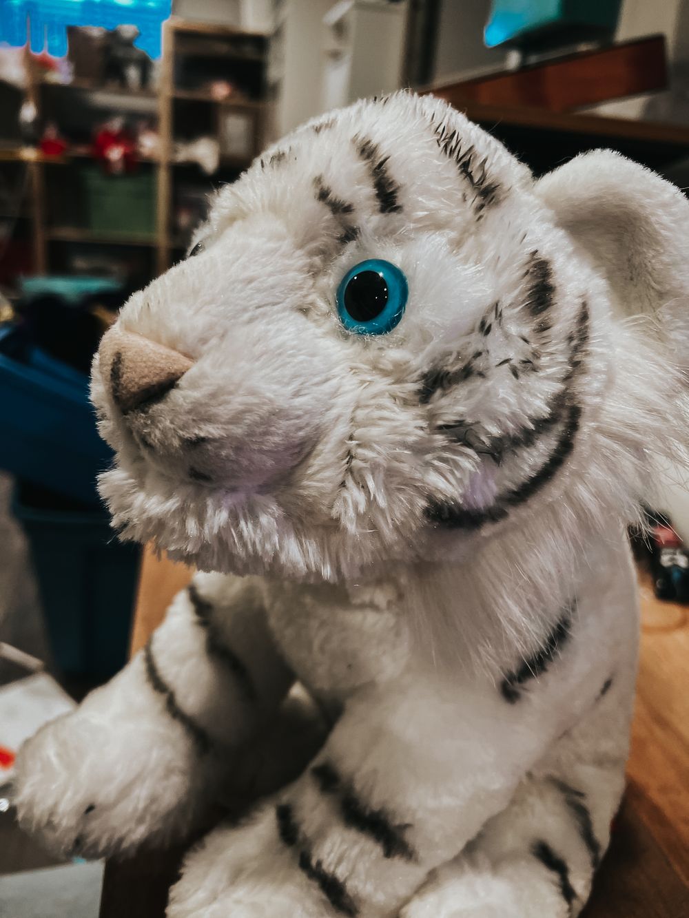 Blue eye of a stuffed white tiger from Wild Republic during sewing repair after damage from a dog.