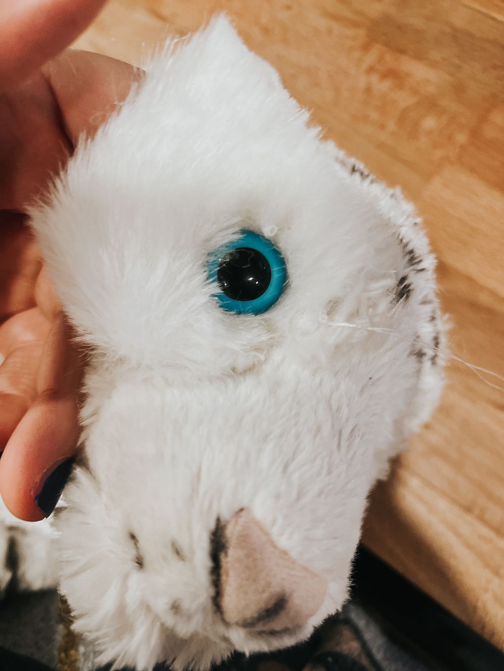 Side view of a Wild Republic stuffed white tiger in mid eye repair with a piece of white faux fur.