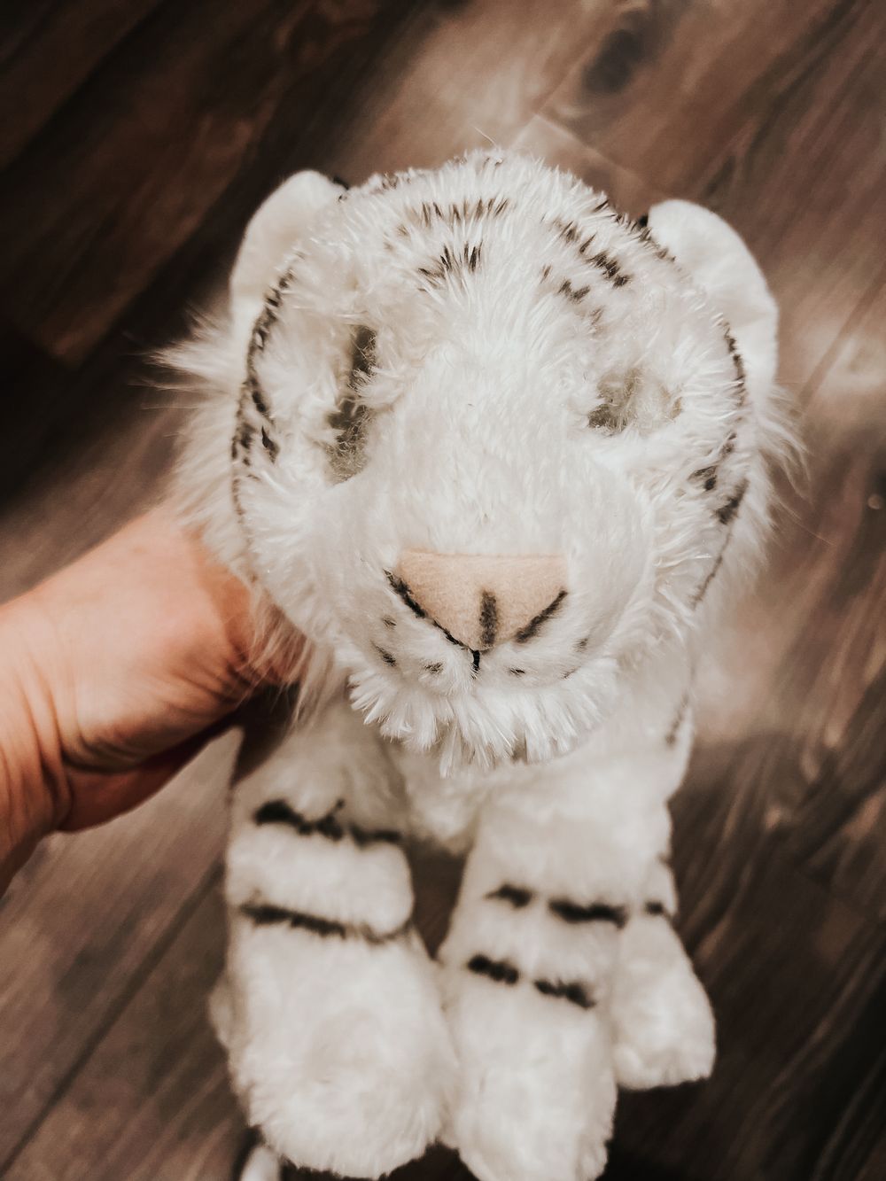 A Wild Republic stuffed toy white tiger missing both of its eyes.