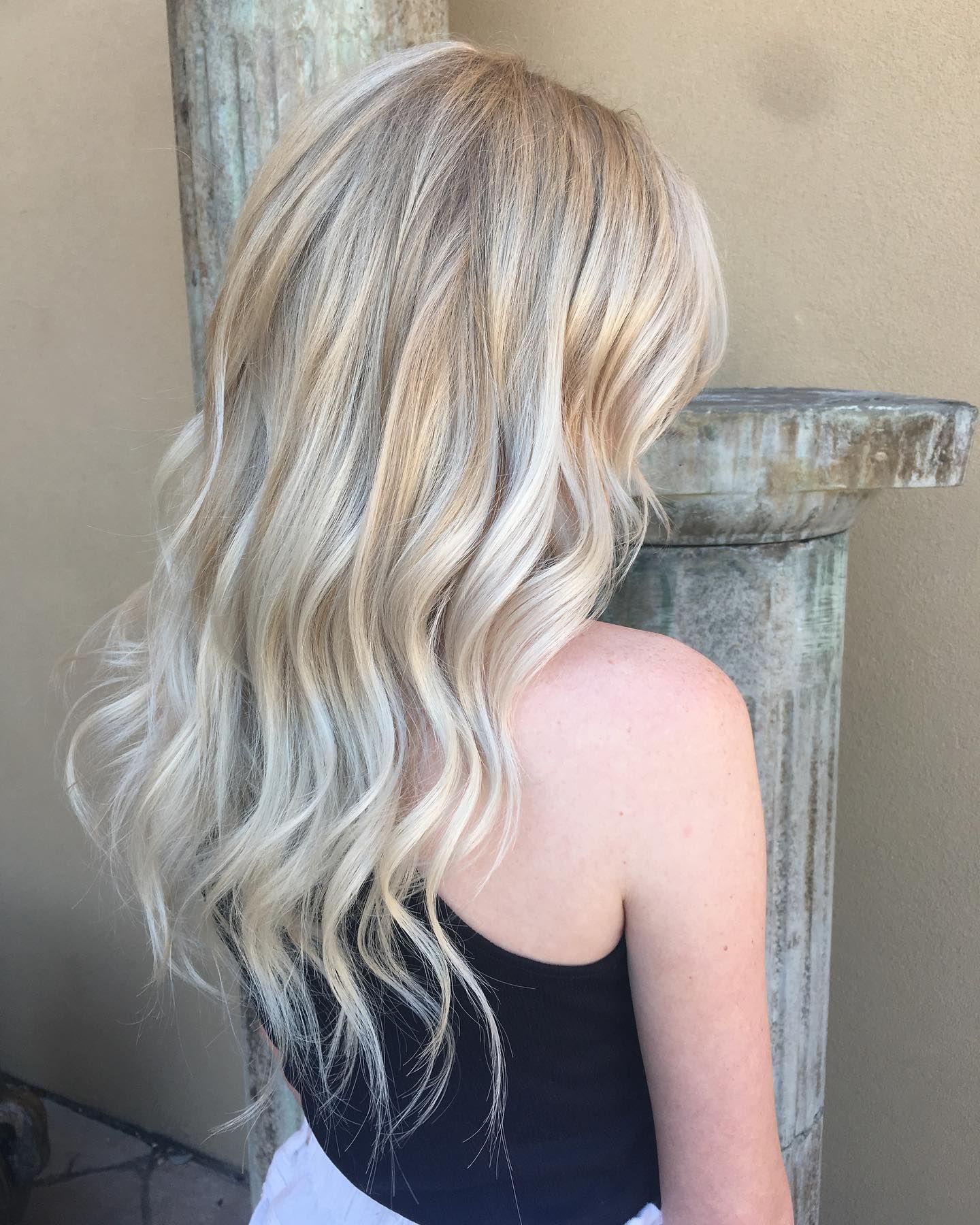 Platinum blonde wavy hairstyle photographed from behind showing dimensional color and texture.