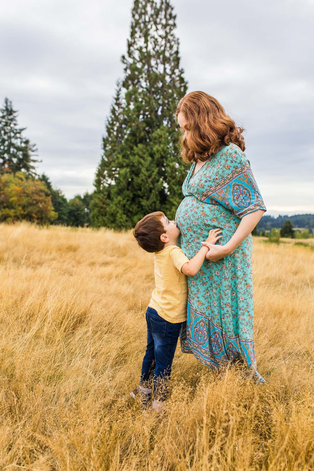 Photographer captures son kissing mom's baby bump