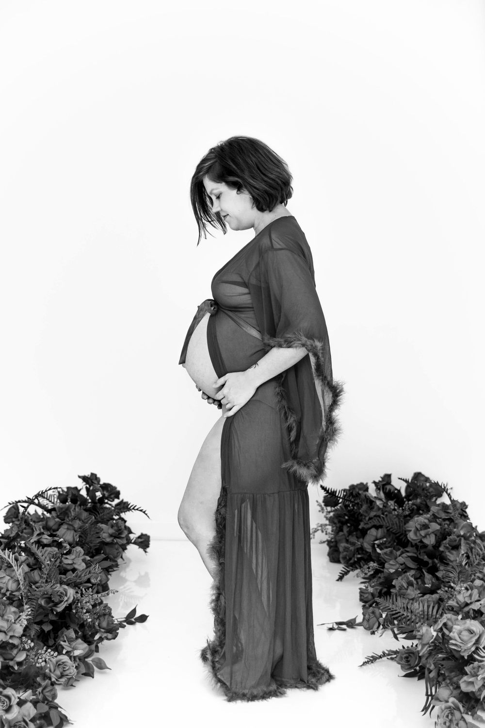 Black and white image of a posing pregnant woman.